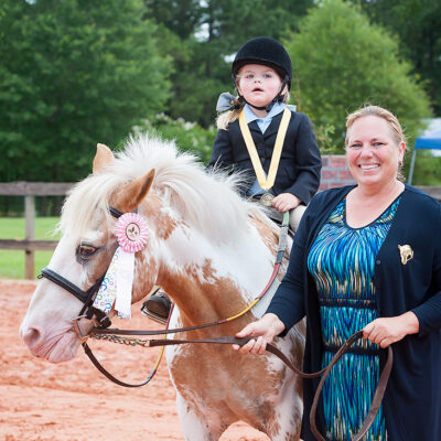 A woman and child riding on the back of a horse.