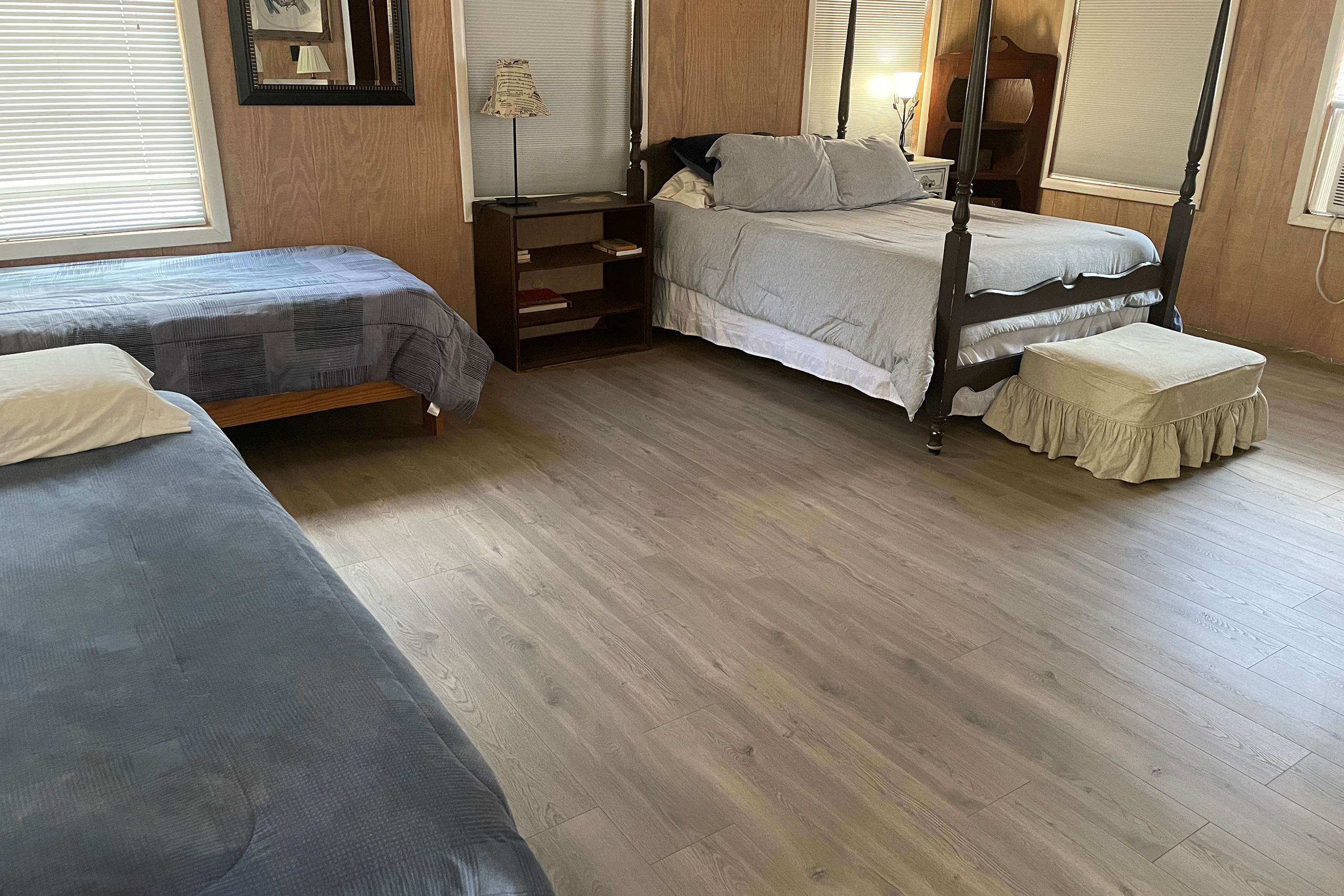 A bedroom with two beds and a dresser.